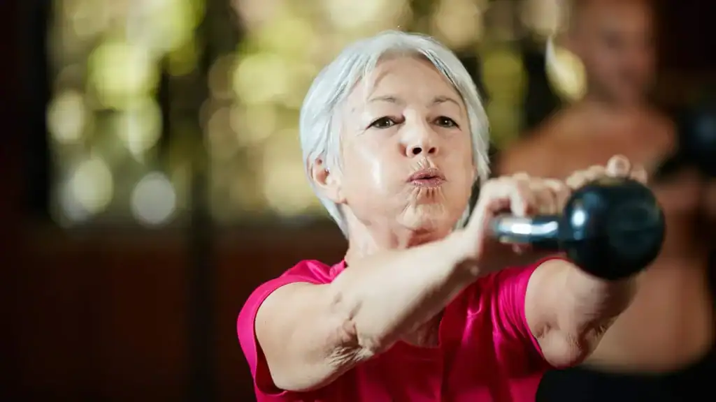 Toning Arms After 60: Empowering Womens Fitness Through Effective Weight Training 1 Older woman doing weight training Oxfordshire to help her strength and longevity