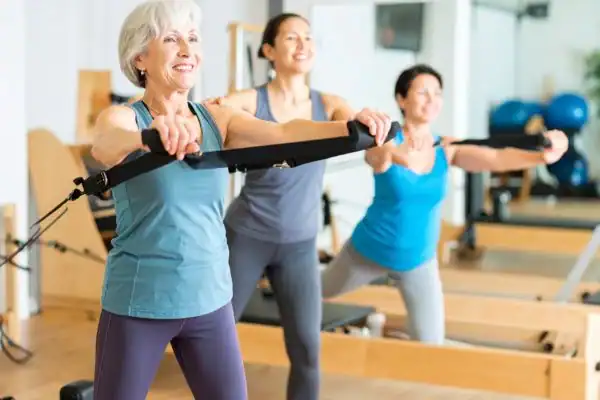 Toning Arms After 60: Empowering Womens Fitness Through Effective Weight Training 2 older woman doing weight training Oxfordshire and resistance in the gym to tone upper arms