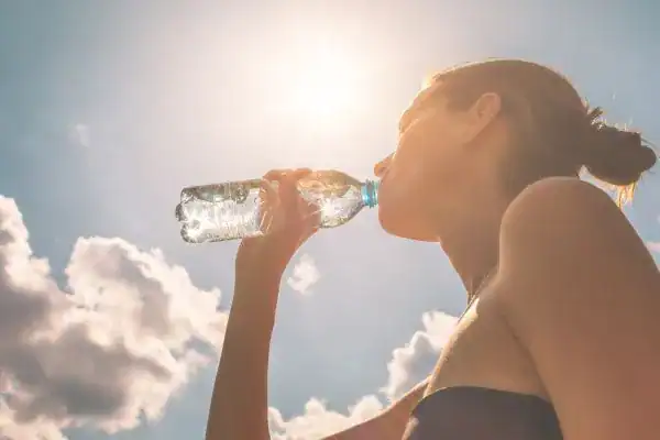 Hydration: The Secret Ingredient for a Toned Stomach and Enhanced Fitness 3 Image of woman drinking water to hydrate Oxfordshire after run.