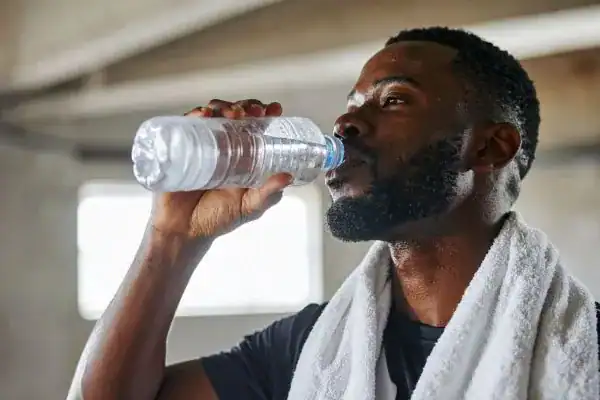 Hydration: The Secret Ingredient for a Toned Stomach and Enhanced Fitness 1 Image of man drinking water to improve hydration Oxfordshire after work out.